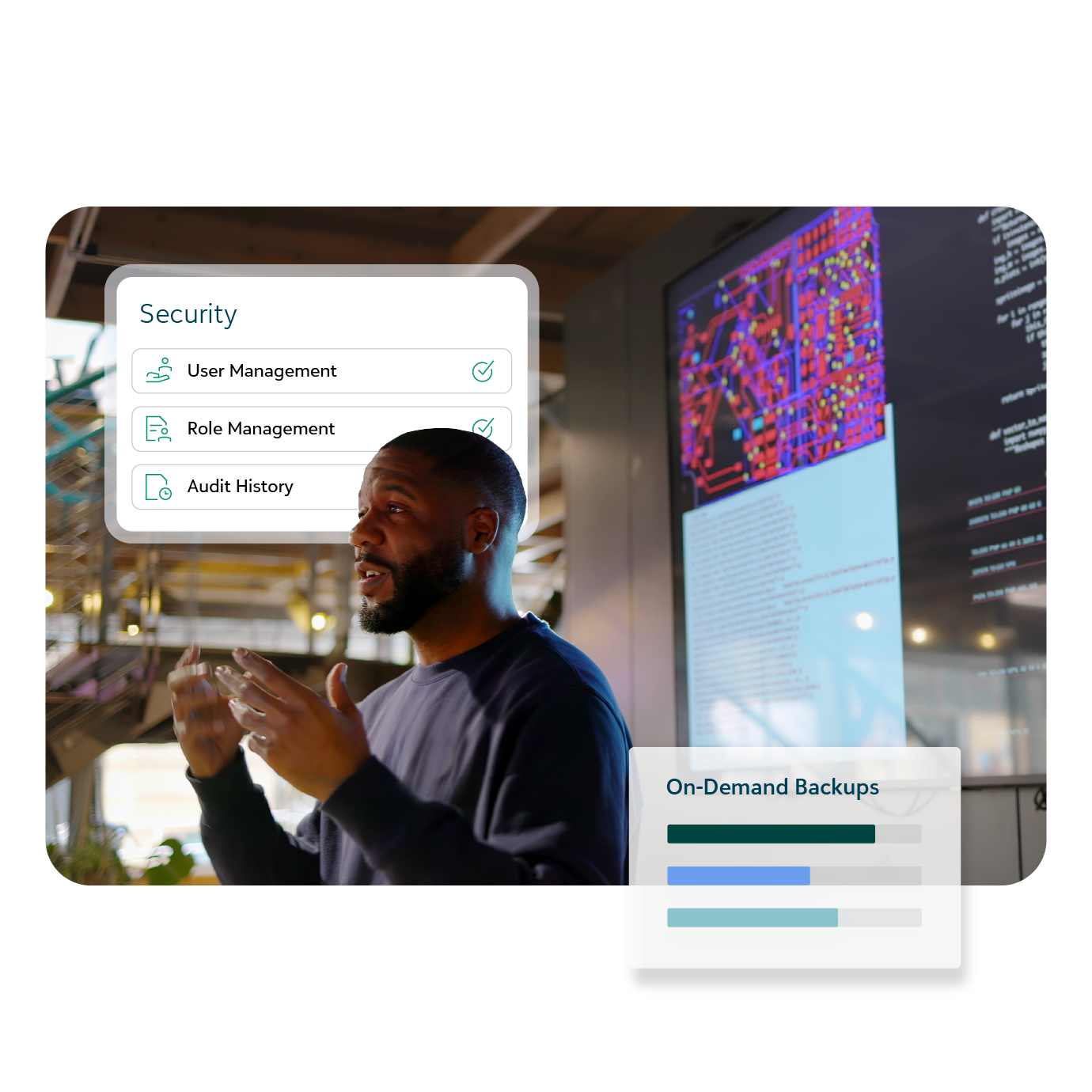 Man in front of computer displays with graphics for security controls and on-demand backups.