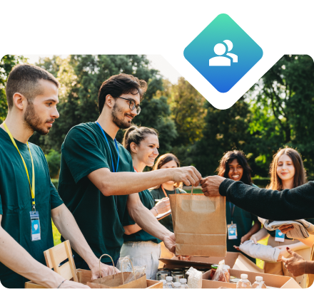 A group of volunteers handing out a bag of food.